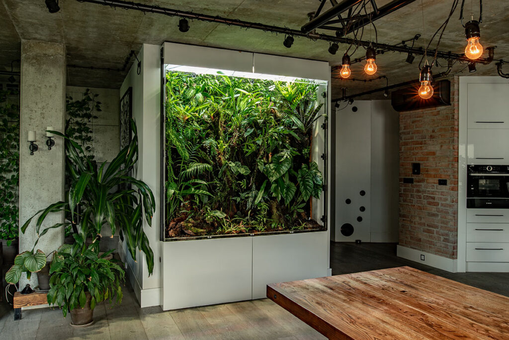 Wielkogabarytowe akrylowe terrarium roślinne jest unikatową dekoracją przestronnego apartamentu na warszawskiej Woli.